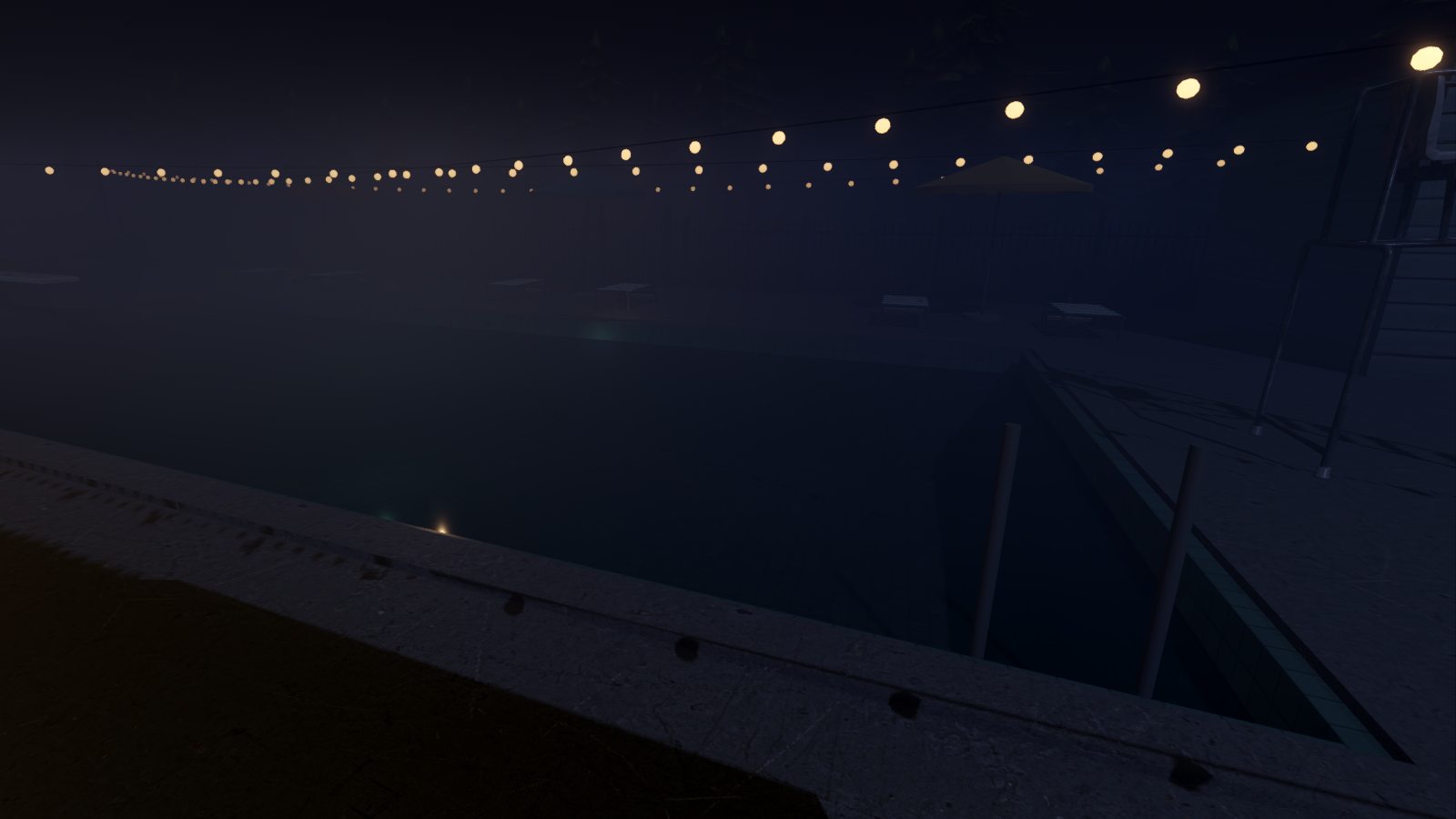 The motel pool at night, dark water under string lights in the fog